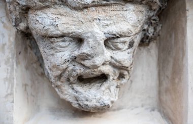 Trento, İtalya, Haziran 2021. Bir evin ön cephesinde taştan yapılmış eski bir yüzün rahatlaması. Zaman, yüzün özelliklerini bozdu. Bu da tanınmayı zorlaştırıyor..