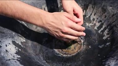 Sıcak bir yaz gününde, içme suyu çeşmesinde ellerini serinlet..