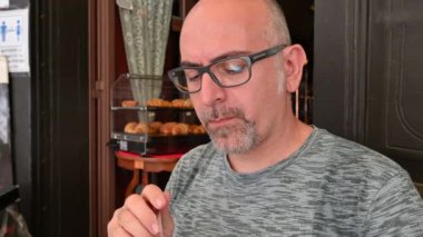 Tatillerde kahve kreması içen orta yaşlı beyaz bir adamın portresi. Rahatlama ve ferahlatıcı dinlenme kavramı.