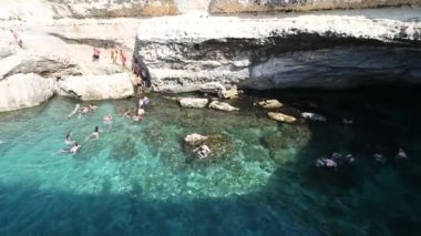 Roca Vecchia, Melendugno, Puglia İtalya. Ağustos 2021. Grotta della Poesia 'nın görüntüsü, açık denize bağlı inanılmaz bir doğal havuz. İnsanlar dalarak cennetin tadını çıkarıyorlar. Pan hareketi.