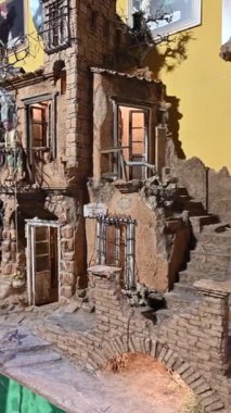 Napoli, İtalya, 27 Aralık 2024. Via S. Gregorio Armeno 'nun dikey görüntüleri. Satılık bir İsa 'nın doğumu sahnesi hazırlıyorum. Bir çocuğun eli ona dokunmak için uzanıyor. Turistik yerler.