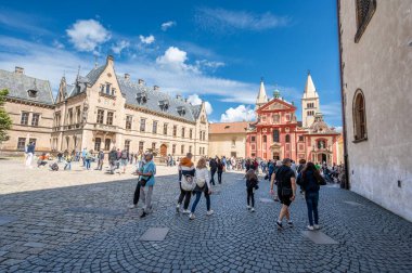 Prag, Çek Cumhuriyeti, 8 Ağustos 2023. San Vito 'nun Katedral Meydanı' ndaki güzel bir yaz gününün kamera görüntüleri. İnsanlar burayı ziyaret ediyor. San Giorgio Bazilikası 'nın kırmızı cephesi öne çıkıyor.