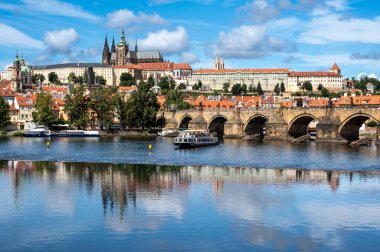 Prag, Çek Cumhuriyeti, 9 Ağustos 2023. Vltava Nehri 'nin ayaklarının altından geçtiği, turist teknelerinin geçtiği, şatonun büyüleyici manzarası ve tepeye hakim olan katedral..