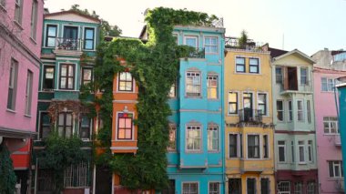 İstanbul, Türkiye, Ağustos 12025. Tarihi Balat Mahallesi 'nin renkli cephelerinin görüntüleri. Canlı renkleriyle Iconic, rüzgarda uçan santrallere tırmanıyor. Güzel bir yaz günü.