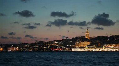 İstanbul, hindi, 4 Ağustos 2025. Meşhur İstanbul gökdeleninde alacakaranlıkta aydınlatılmış galata kulesi var. Şehir ışıkları boğazın sakin sularını yansıtıyor.