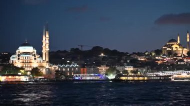 İstanbul, hindi, 4 Ağustos 2025. İstanbul 'un tarihi siluetinin ışıl ışıl parlayan manzarasında, yeni cami ve Süleyman Camii' nin İstanbul Boğazı 'nın üzerinde gece gökyüzüne karşı parlayan manzarası