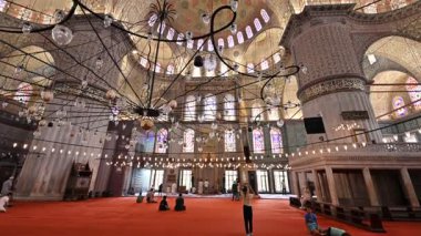 İstanbul, Trkiye, 6 Ağustos 2025. Sultan Ahmed Camii 'nin ya da Mavi Cami' nin içinde. Eğim, tapınanların kırmızı halıda görkemli kubbeye yükselmesiyle başlar. Karmaşık avizeler.