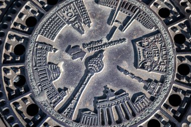 Berlin, Almanya, 11 Ağustos 2023. Berlin rögar kapağı Brandenburg kapısı ve TV kulesi gibi şehir simgelerinin şehir kimliğini temsil eden yardım haritası içeriyor.