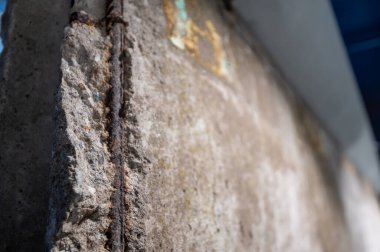 Berlin, Almanya, 13 Ağustos 2023. Berlin duvarının sert beton dokusunu paslanmış demirle gösteren parçası bölünmeyi ve tarihi değişimi simgeliyor.