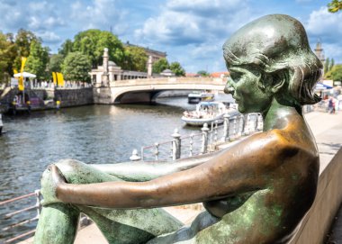 Berlin, Almanya, 13 Ağustos 2023. Bronz heykel, üç kız ve bir oğlan Berlin 'deki eğlence nehri boyunca gezici teknelerle sakin bir ortam yaratıyor.
