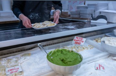 Ceneviz, ligurya, İtalya. 18 Mayıs 2024. İtalyan pazarında büyük bir kase pesto genovese 'nin yanında el yapımı taze ravioli.