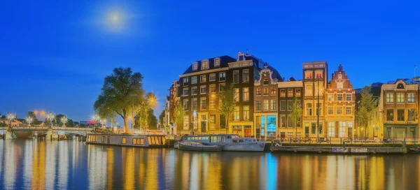Amstel folyó, a csatornák és a éjszakai kilátás gyönyörű Amsterdam city. Hollandia — Stock Fotó