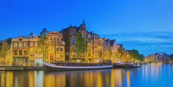 Río Amstel, canales y vista nocturna de la hermosa ciudad de Ámsterdam. Países Bajos — Foto de Stock