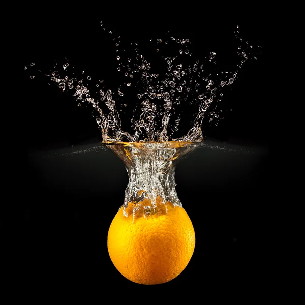 Fresh fruits falling in water with splash on black background — Stock Photo, Image