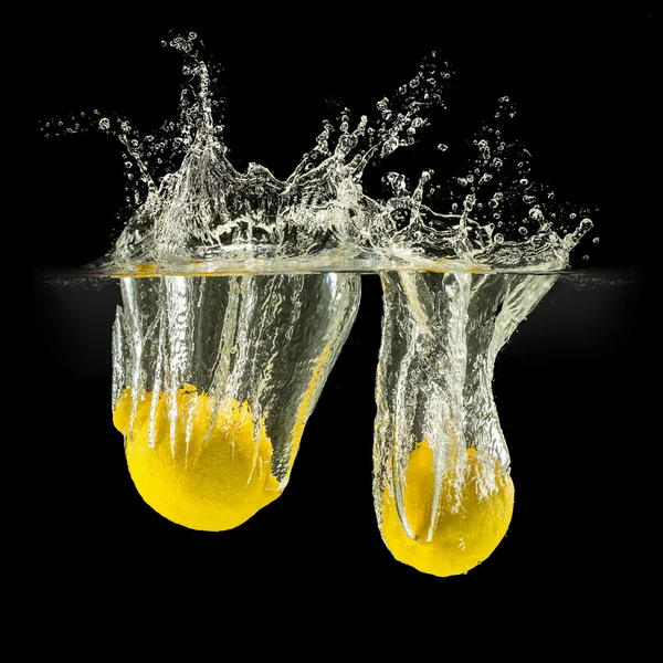 Group of fresh fruits falling in water with splash on black background — Stock Photo, Image