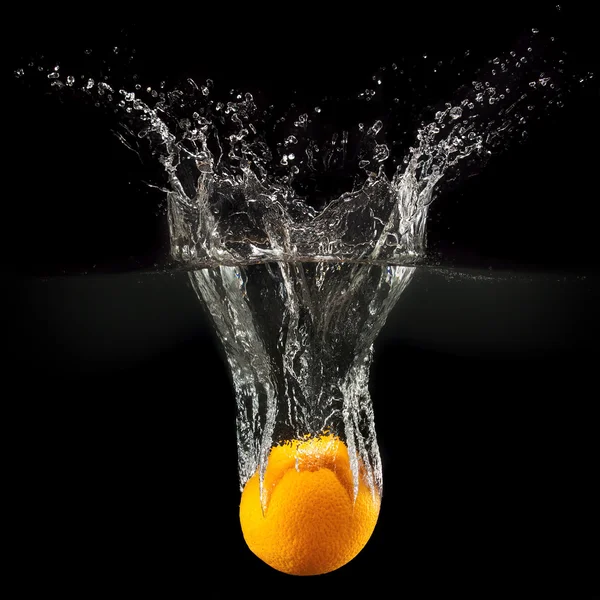 Frische Früchte fallen in Wasser mit Spritzer auf schwarzem Hintergrund — Stockfoto
