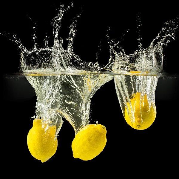 Gruppe frischer Früchte fällt in Wasser mit Spritzer auf schwarzem Hintergrund — Stockfoto