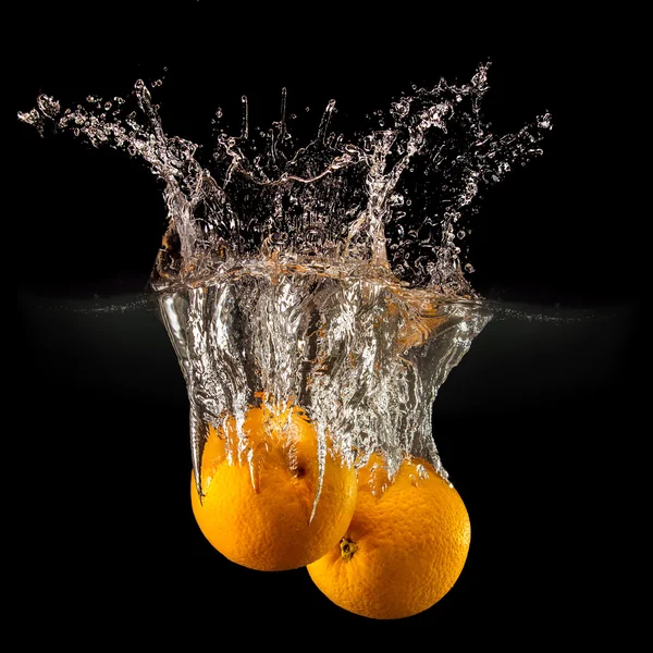 Group of fresh fruits falling in water with splash on black background — Stock Photo, Image