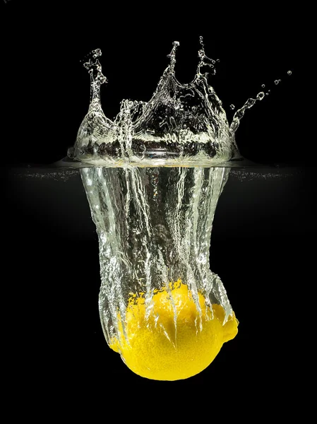 Fresh fruits falling in water with splash on black background — Stock Photo, Image