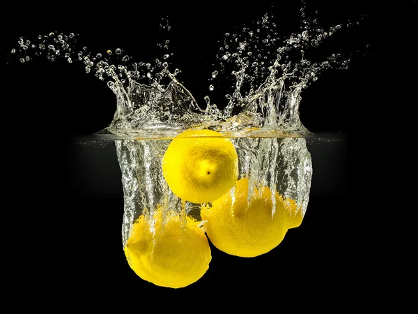 Grupo de frutas frescas que caen en el agua con salpicaduras sobre fondo negro —  Fotos de Stock