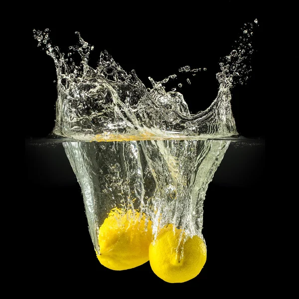 Group of fresh fruits falling in water with splash on black background — Stock Photo, Image