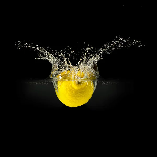 Frutta fresca che cade in acqua con spruzzi su fondo nero — Foto Stock