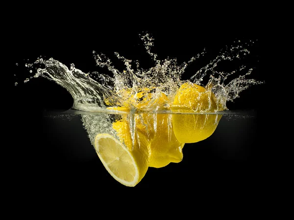 Grupo de frutas frescas que caen en el agua con salpicaduras sobre fondo negro — Foto de Stock