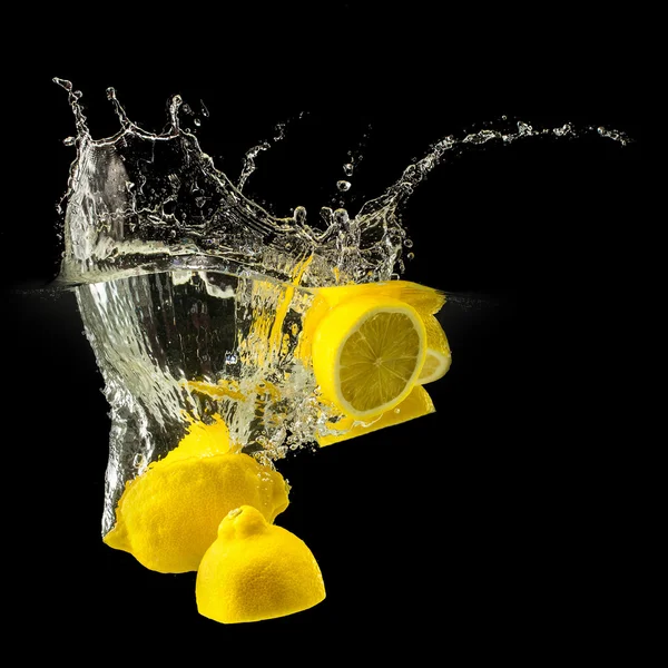 Group of fresh fruits falling in water with splash on black background — Stock Photo, Image