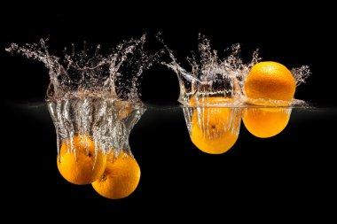 Taze meyve su sıçrama ile siyah arka plan üzerine düşen grup