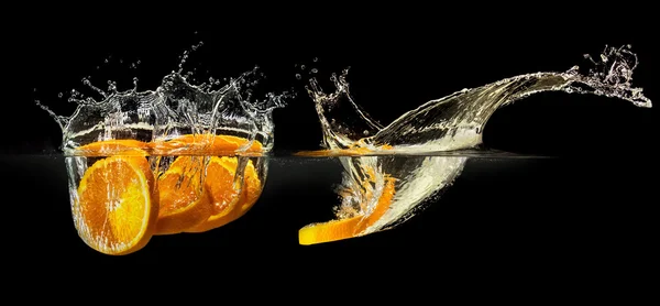 Grupo de frutas frescas caindo na água com respingo no fundo preto — Fotografia de Stock