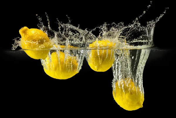 Grupo de frutas frescas caindo na água com respingo no fundo preto — Fotografia de Stock