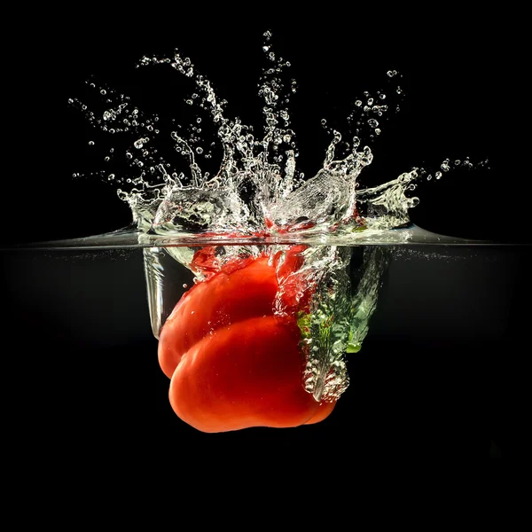 Peperoncino rosso che cade in acqua con spruzzata su fondo nero — Foto Stock