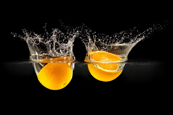 Grupo de frutas frescas que caen en el agua con salpicaduras sobre fondo negro — Foto de Stock