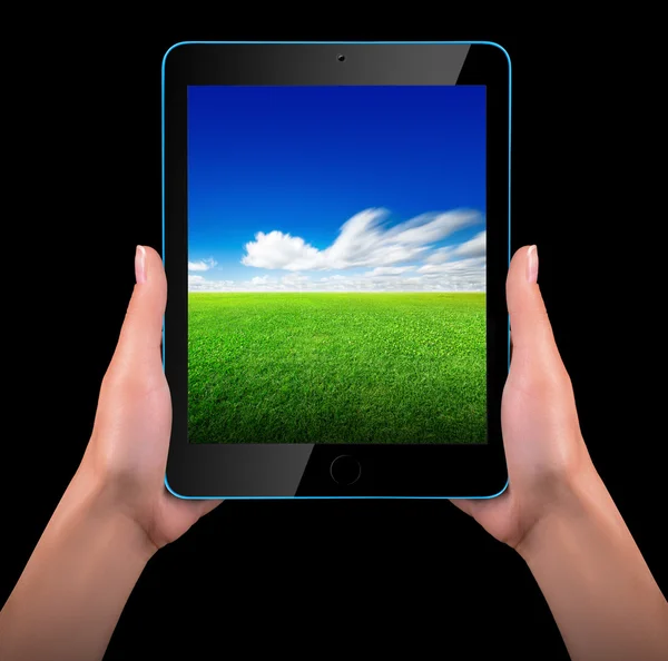 Tabletový počítač s modré oblohy a zelené trávy — Stock fotografie