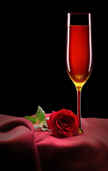Glass of champagne and rose on black — Stock Photo, Image