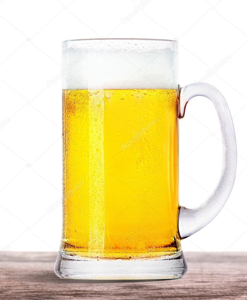 Frosty beer with foam isolated on wooden table