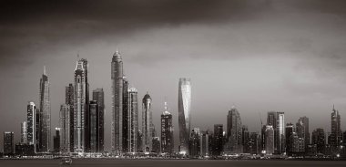 Tek renkli şehir gökdelenleri bulutlu bir gökyüzü altında sakin suyu yansıtan gökdelenler, kentsel gelişim konsepti, Dubai Marina Körfezi BAE