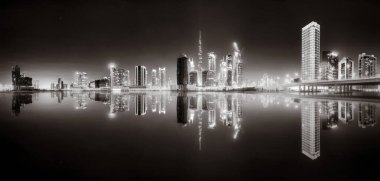 Aydınlatılmış gökdelenleri ve gece siyah beyaz rıhtımlı şehir silüeti, kentsel gelişim konsepti, Dubai Marina Körfezi BAE