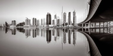 Gökdelenler ve su üzerindeki köprü, siyah-beyaz tarzı, şehir arkaplanı, şehir gelişimi konsepti, Dubai Marina körfezi BAE
