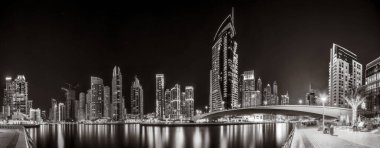 Gökdelenler ve su üzerindeki köprü, siyah-beyaz tarzı, şehir arkaplanı, şehir gelişimi konsepti, Dubai Marina körfezi BAE