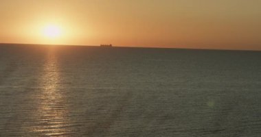 Ufukta okyanus mor akşam güneşi, yaz akşamı alacakaranlıklarında ve Asyalı denizcilerin sakin deniz manzarası. 4K video.
