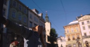 Ağır çekimde, uzun sarı saçlı, kot ceketli, sarı formalı ve sarı sırt çantalı ve gülümseyen mutlu genç bir kadın..