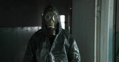 Gaz maskeli ve yağmurluklu bir adamın yakın plan portresi. Özel giyinmiş bir adamın portresi. İnsan yapımı bir felaket. Teknojenik felaket. Ekolojik felaket. Ekolojik bir felaket. virüs