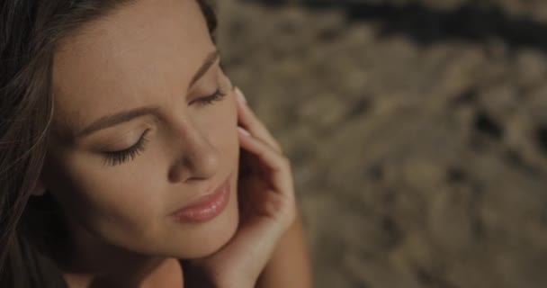 Close up de menina atraente sentado na praia. Menina bonita com um sorriso bonito. Verão. — Vídeo de Stock