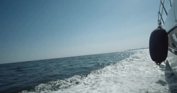 Piccola nave da crociera bianca sta navigando in mare. Vista laterale POV di yacht. Traccia d'onda con schiuma. Video 4K. Colpo al rallentatore. — Video Stock