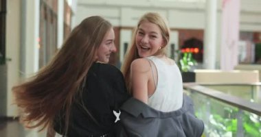 Şık arkadaşlar alışveriş merkezinde yürüyor, gülüyor ve sarılıyorlar. Mutlu arkadaşlar başarılı bir alışverişten sonra evlerine giderler. 4K video