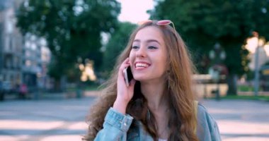 Çekici bir kız şehre gider ve telefonda konuşur. Güzel kız telefonda konuşuyor ve şehirde dolanıyor..