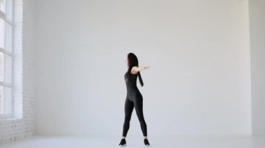 Yeni başlayanlar için pilates dersleri. Genç kaslı sporcu, beyaz izole stüdyoda kollarını iki yana açıyor..