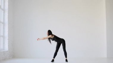 Yeni başlayanlar için spor ve spor dersleri. Kaslı ince kadın sırt kaslarını esnetiyor. Öne ve yana doğru eğiliyor..