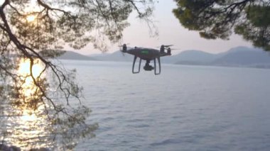 Gün batımında güzel okyanusun üzerindeki dron. Arkadaki dağların panorama manzarası.